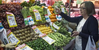 En la foto, una mujer hace su compra en una fruteria de un mercado en Madrid. 