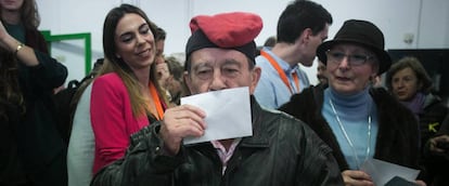 Un hombre con una barretina besa su voto antes de introducirlo en la urna en Barcelona.