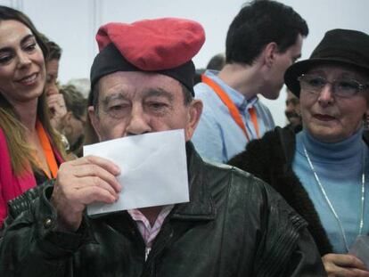 Un hombre con una barretina besa su voto antes de introducirlo en la urna en Barcelona.