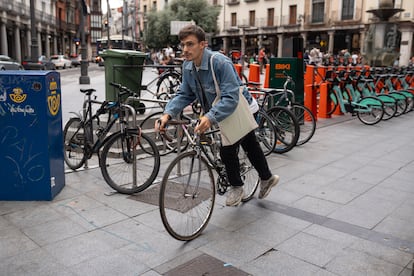 Un joven coge su bici de uno de los aparcamientos del centro de Valladolid.