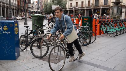 Un joven coge su bici de uno de los aparcamientos del centro de Valladolid.