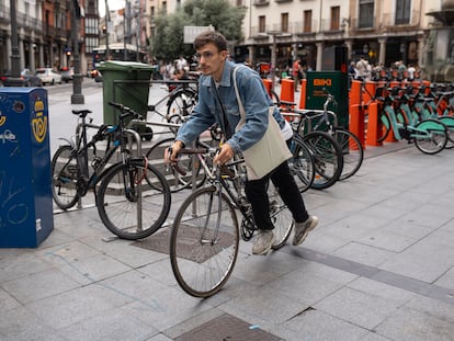 Un joven coge su bici de uno de los aparcamientos del centro de Valladolid.