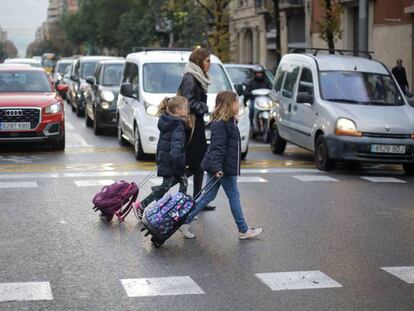 Diverses persones travessen un pas de vianants al transitat carrer Aragó de Barcelona.