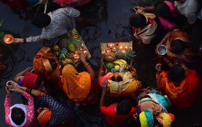Indian Hindu devotees perform religious rituals as they offer prayers to the sun god on the banks of the Yamuna river during the Chhath Festival in Allahabad on October 26, 2017. 
The Chhath Festival, also known as Surya Pooja, or worship of the sun, is observed in parts of India and Nepal and sees devotees pay homage to the sun and water gods. Devotees undergo a fast and offer water and milk to the sun god at dawn and dusk on the banks of rivers or small ponds and pray for the longivety and health of their spouse. / AFP PHOTO / SANJAY KANOJIA
