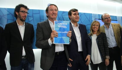 Ramón Riera, el segundo por la izquierda, posa con un documento del PP. 
