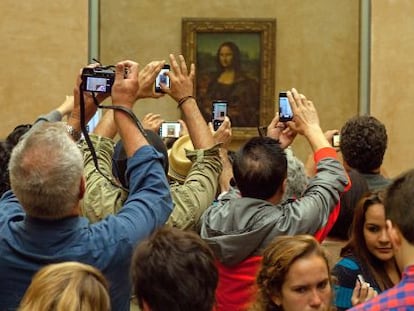 Decenas de turistas fotograf&iacute;an la Mona Lisa en el Louvre.