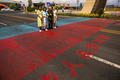 Visitantes del Centro de Cooperación Internacional Transfronterizo, una zona de libre comercio entre China y Kazajistán, se retratan sobre la línea que marca la frontera entre ambos países. 
