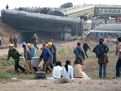 Los equipos de rescate evacuan cadáveres del lugar del accidente de trenes en Zibo, al norte de la provincia china de Shangdong.