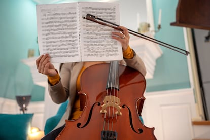 A woman reads a score with a cello in the foreground.