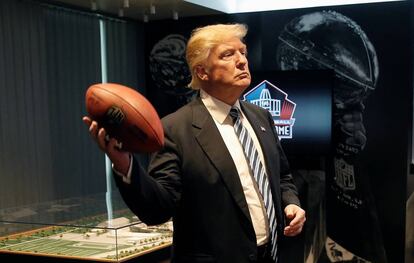 Trump con un balón de fútbol americano.