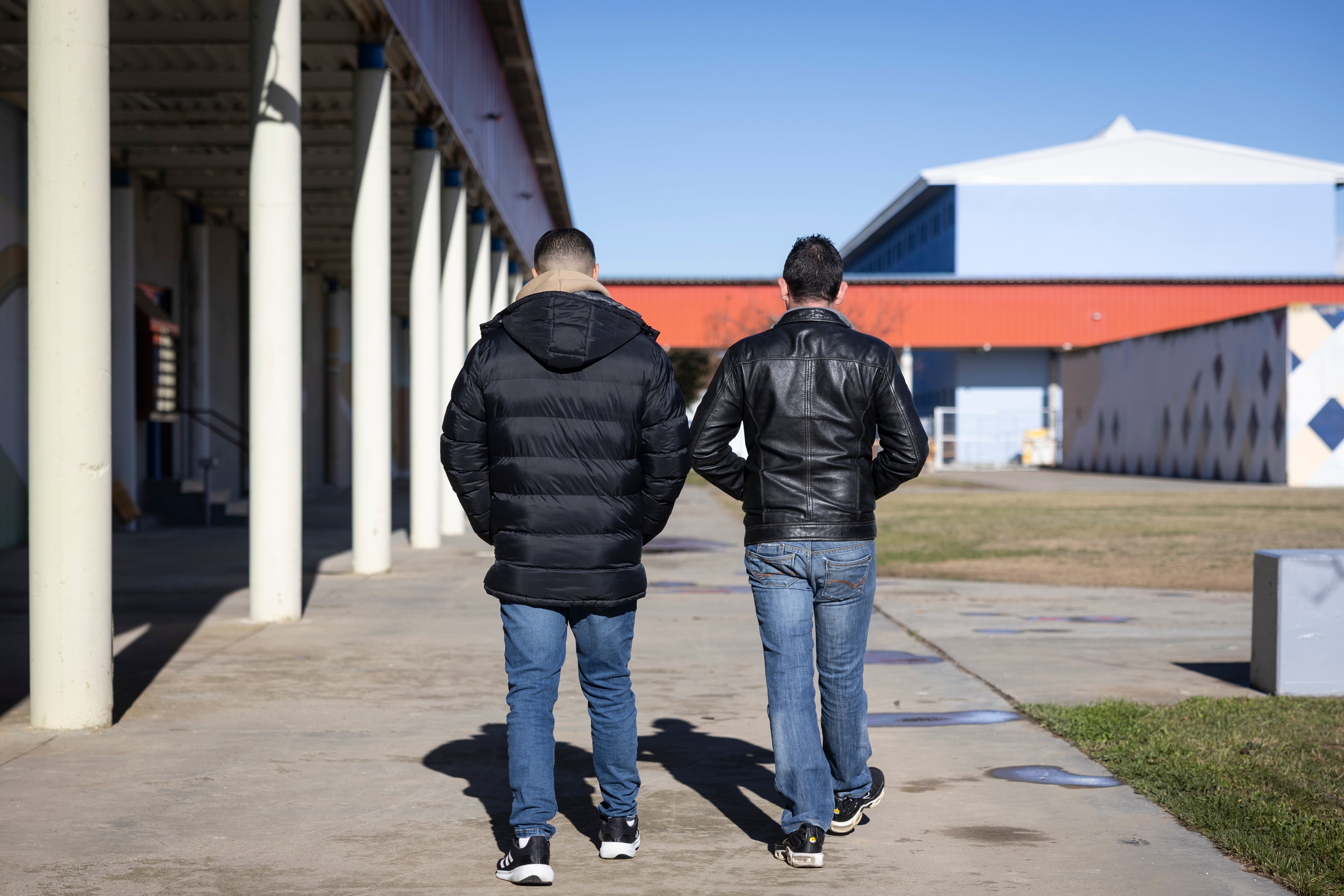 Dos presos del centro Penitenciario de Zuera (Zaragoza) que están estudiando, caminan en una zona al aire libre.