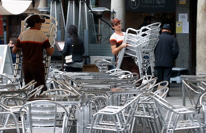 Varios trabajadores preparan las mesas de una terraza en un bar de Toledo en enero.