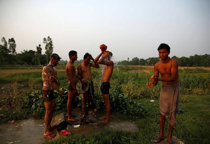 Un grupo de operarios indios se lavan después de trabajar en la construcción de un puente para el nuevo ferrocarril en Janakpur, Nepal.