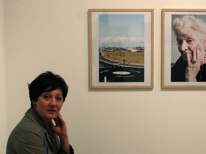 La fotógrafa Ione Saizar posa ante dos de las instantáneas de <i>Please take all the baggage with you</i>.
