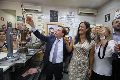 Almeida y Villacís brindan con cerveza en un bar cercano a la parroquia de la virgen de La Paloma.