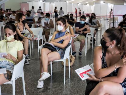 Varios jóvenes esperan tras ponerse la primera dosis de la vacuna contra el coronavirus en Valencia.