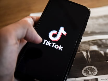 Un móvil con el logo de TikTok sobre una imagen de Donald Trump en un periódico.