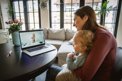 Una madre con su hijo realiza una videoconsulta.