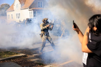 Un agente apunta a manifestantes en una protesta en East Side, Chicago, el 14 de octubre.