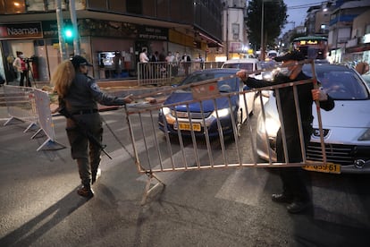 Policías israelíes instalan un puesto de control en la ciudad ultraortodoxa israelí de Bnei Brak al anochecer del martes.