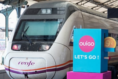 Un tren de Renfe pasa junto a un cartel publicitario de Ouigo el día en que la compañía francesa inauguraba su nuevo trayecto Madrid-Segovia-Valladolid.