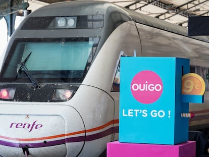 Un tren de Renfe pasa junto a un cartel publicitario de Ouigo, esta mañana en Valladolid.