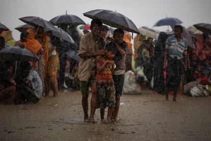 Refugiados rohinyás intentan resguardarse de las lluvias torrenciales mientras están retenidos por la Guardia Fronteriza de Bangladesh (BGB), después de cruzar ilegalmente la frontera, en Teknaf (Bangladés), el 31 de agosto de 2017.