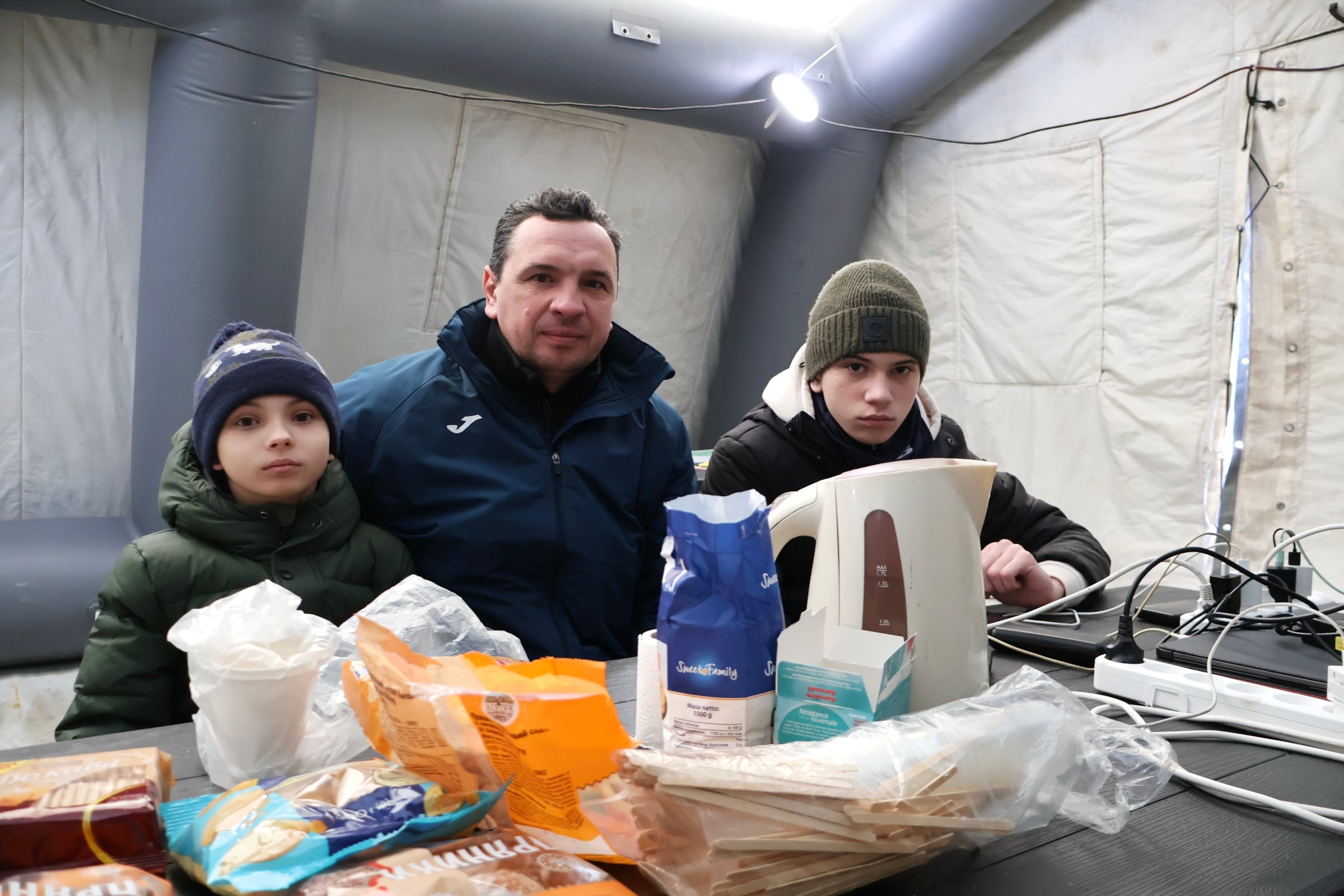 Mijailo Kisilichin y sus hijos, el 12 de enero en una tienda de emergencias de Brovarí, Ucrania.