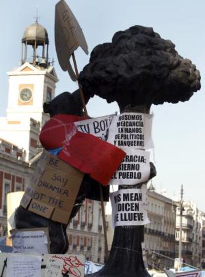 El oso y el madroño de la madrileña Puerta del Sol permanece forrado con carteles con diversos lemas.