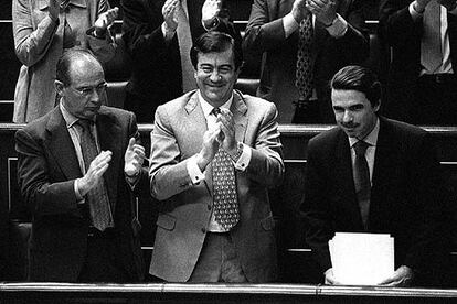 José María Aznar recibe en su escaño los aplausos de sus diputados en presencia de Rodrigo Rato y Francisco Álvarez Cascos.
