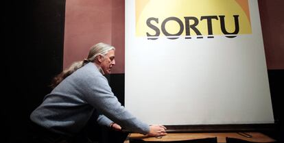 Un hombre coloca el logo de Sortu minutos antes del inicio de una rueda de prensa en Madrid.
