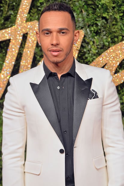 Lewis Hamilton, que últimamente no se pierde una cita con la moda, posó con chaqueta bicolor en la alfombra roja.