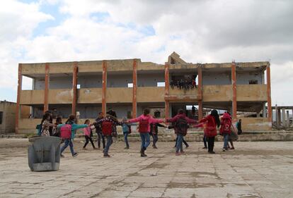 Niños sirios juegan en el patio de una escuela que fue bombardeada en el distrito de Jisr al-Shughur, al oeste de la provincia de Idlib, en su mayoría rebelde.