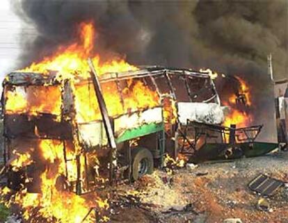 El autobús objeto del atentado suicida arde tras la explosión