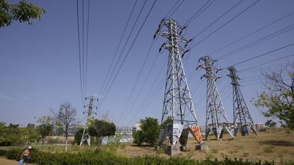 Una persona pasa cerca de varias torres eléctricas en Madrid.