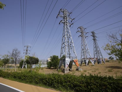 Una persona pasa cerca de varias torres eléctricas en Madrid.