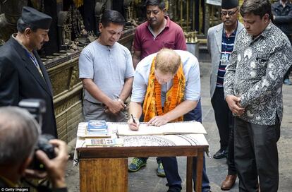 El príncipe Enrique sacó tiempo para firmar un libro de visitas, rodeado por varias autoridades de la zona y la prensa.