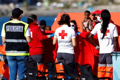 Migrantes junto a miembros de la Cruz Roja s u llegada al puerto de Arguineguin (Gran Canaria), este domingo.