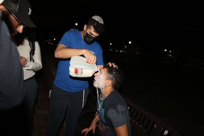 Un joven pro-Israel pone leche en la cara de otro luego de que fuera rociado con gas pimienta, el martes por la noche.