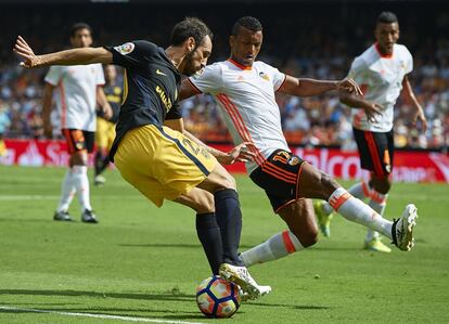 Nani (d) del Valencia lucha por el balón frente a Juanfran Torres, del Atlético de Madrid (c).