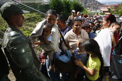 La Guardia Nacional controla el acceso de los clientes a un supermercado en la capital venezolana. En Catia, al oeste de Caracas, una multitud saqueó el jueves un camión que transportaba pañales, otro de los productos muy demandados en estos días, mientras esperaba en una fila.