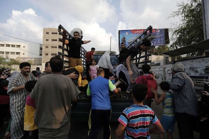 Um grupo de palestinos sobe em um caminhão tentando fugir de Gaza, em 20 de julho de 2014.