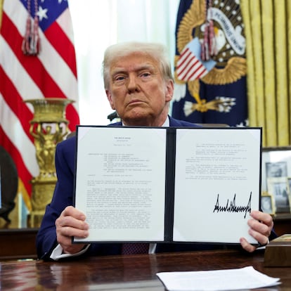 U.S. President Donald Trump holds an executive order about tariffs increase, flanked by U.S. Commerce secretary Howard Lutnick, in the Oval Office of the White House in Washington, U.S., February 13, 2025.  REUTERS/Kevin Lamarque