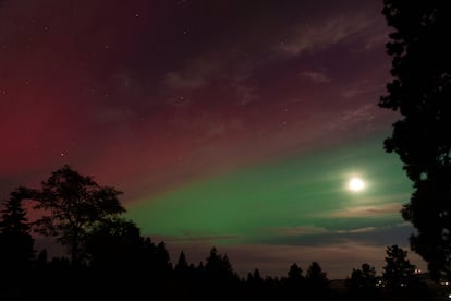 La luna brilla a través de una aurora boreal la noche del jueves 10 de octubre de 2024, en Moscú, Idaho (Estados Unidos).