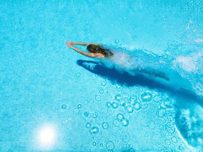 Una mujer se da un chapuzón en una piscina.