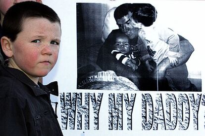 Coneald, hijo de Robert McCartney, asesinado a cuchilladas tras ser apaleado en Belfast, ayer junto a un cartel en el que se lee "¿Por qué mi papá?".