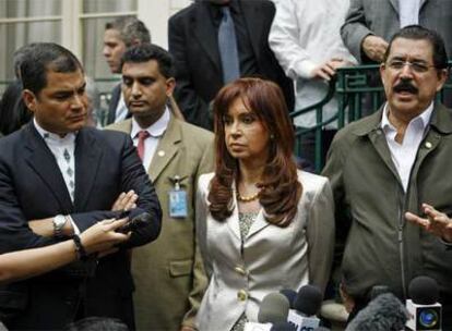 Los presidentes de Ecuador, Rafael Correa (izquierda), y Argentina, Cristina Fernández, junto a Manuel Zelaya, ayer
en Washington. A la derecha, policías en el aeropuerto de Tegucigalpa.