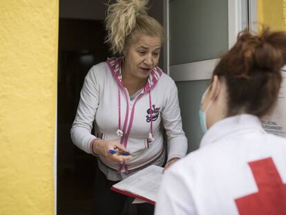 Cristina, voluntària de Creu Roja, porta menjar a Yoslen Garrido, al barrio de Nou Barris. 