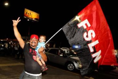 A supporter of Nicaragua's President Daniel Ortega holds up a flag of the Sandinista National Liberation Front in Managua.