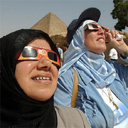 Dos mujeres egipcias contemplan, protegidas con gafas especiales, el tránsito en El Cairo.